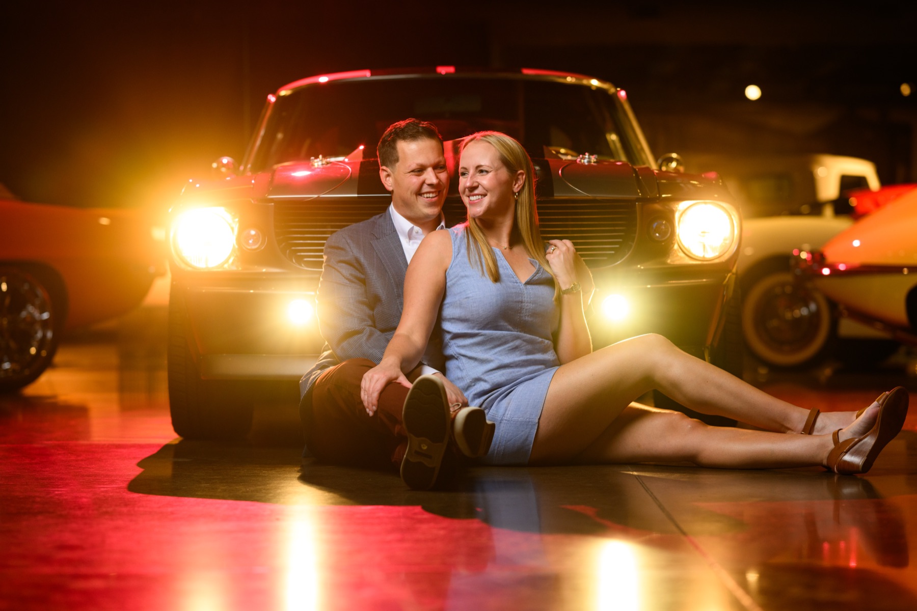 Miranda Christian seated in front of a classic car at a museum.